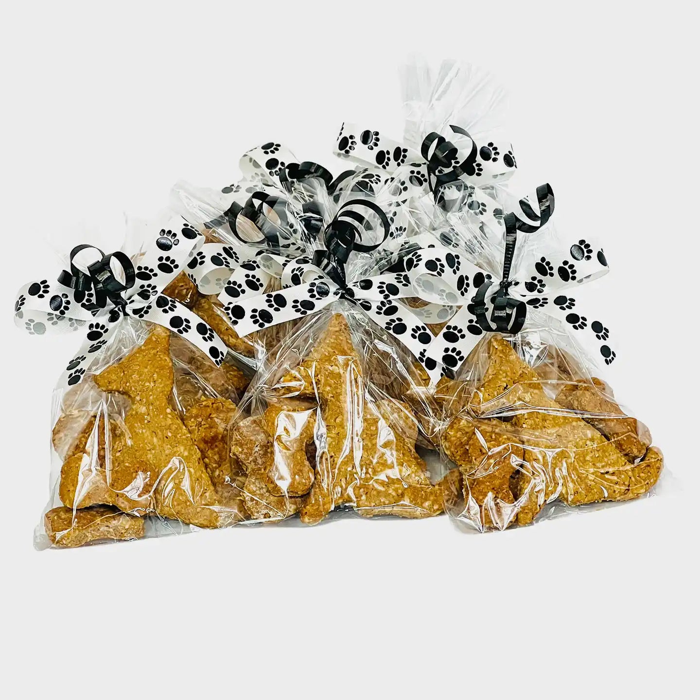 Meeko's dog and bow Treats, packaged in a cellophane bag and tied with ribbons.