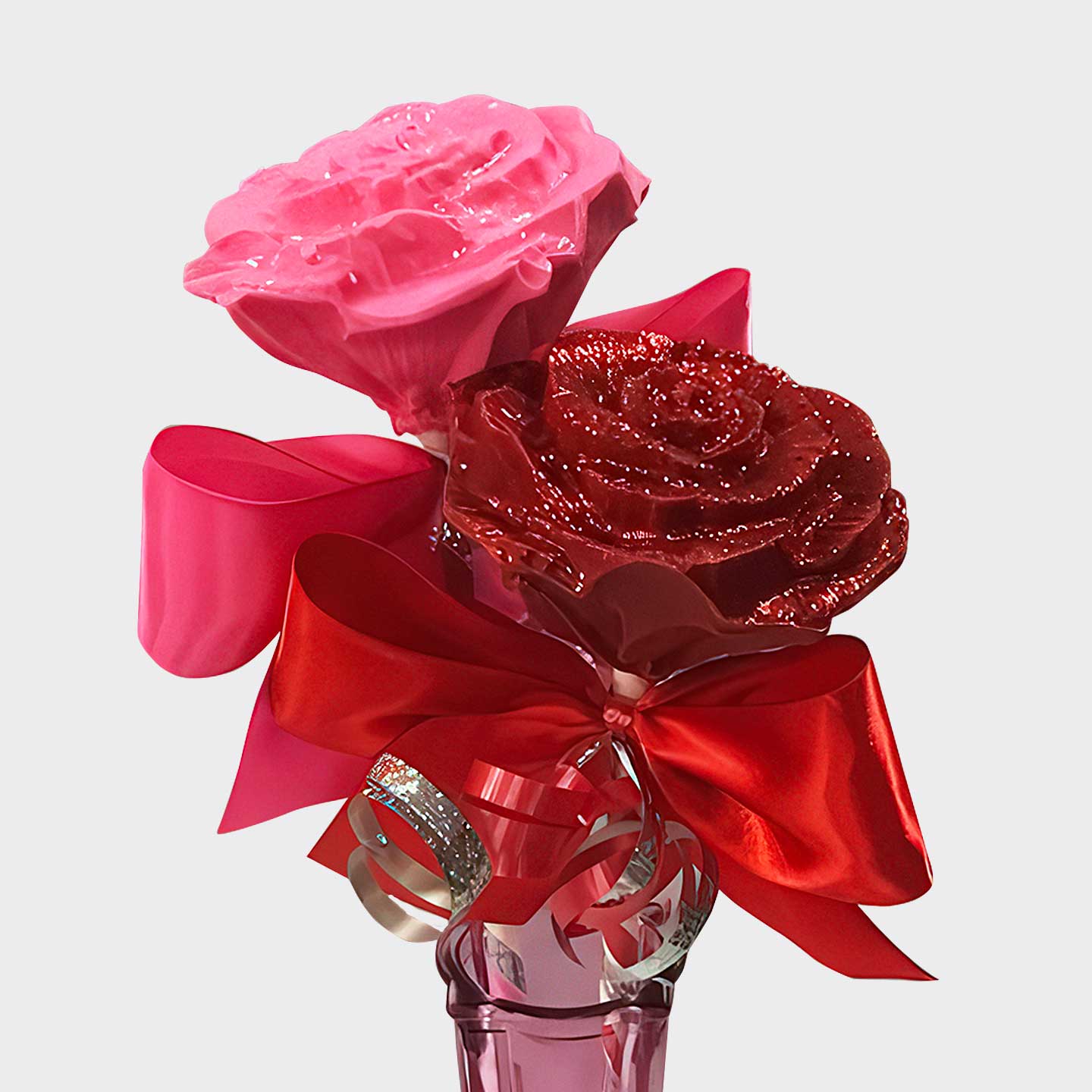 A pink and red chocolate roses, each elegantly tied with satin ribbon