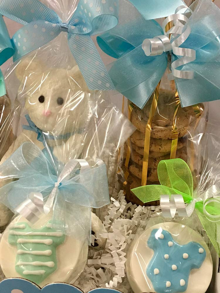 It's A boy git box: 2 bags of mini chocolate chip cookies, solid 3D white chocolate bear, chocolate baby bootie, and 2 chocolate covered Oreos all wrapped in cello and tied with Rosa Wrap satin bow.