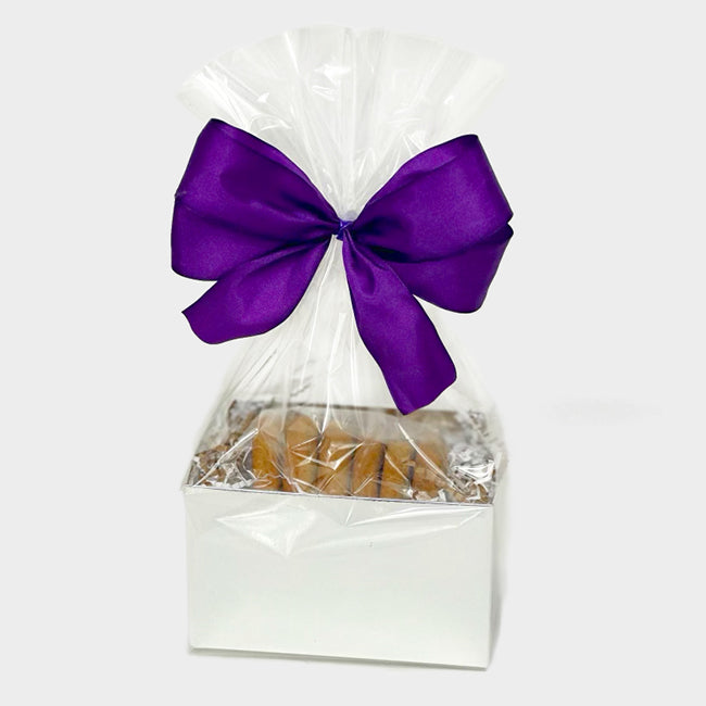 White box of cookies wrapped in cellophane with a ribbon