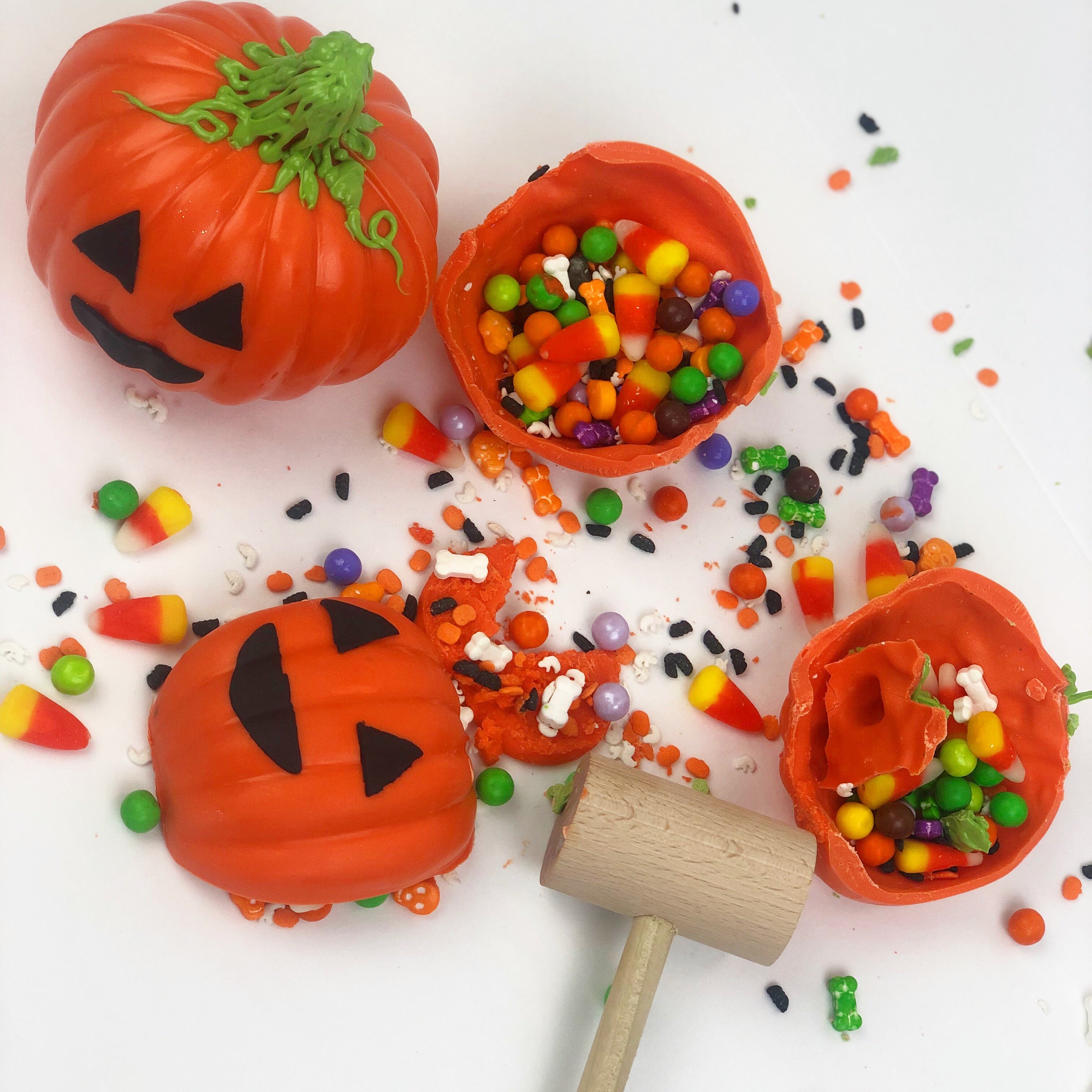 Halloween Jack-O-Lantern Piñatas cracked open with a mallet