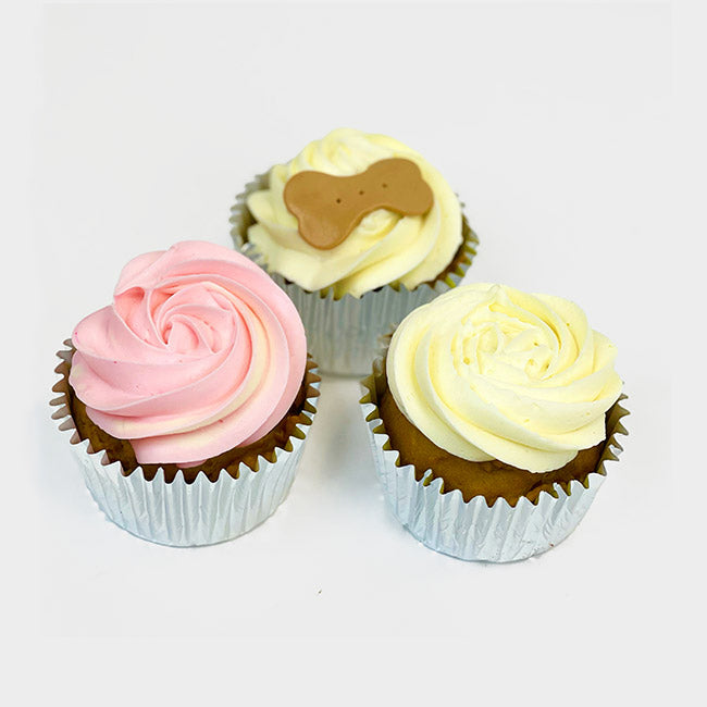 Pup Cupcakes with pink and wolf ivory swirls and one has an edible beige bone on top