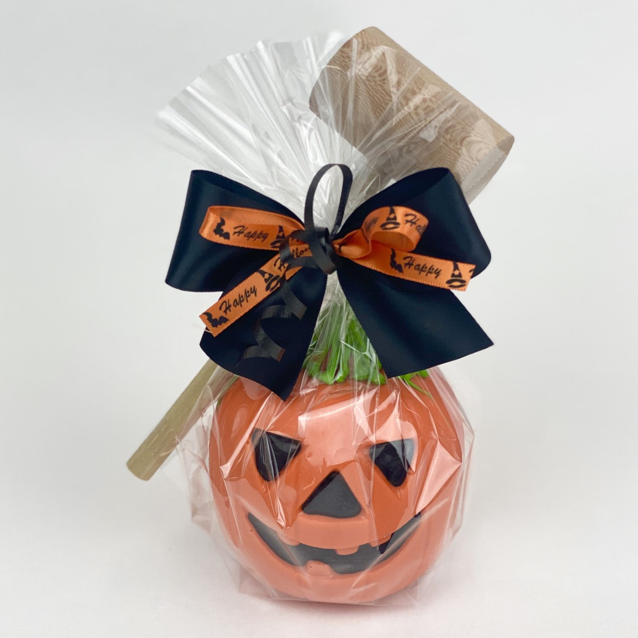 Halloween Jack-O-Lantern Piñata with a mallet wrapped in cellophane with ribbons