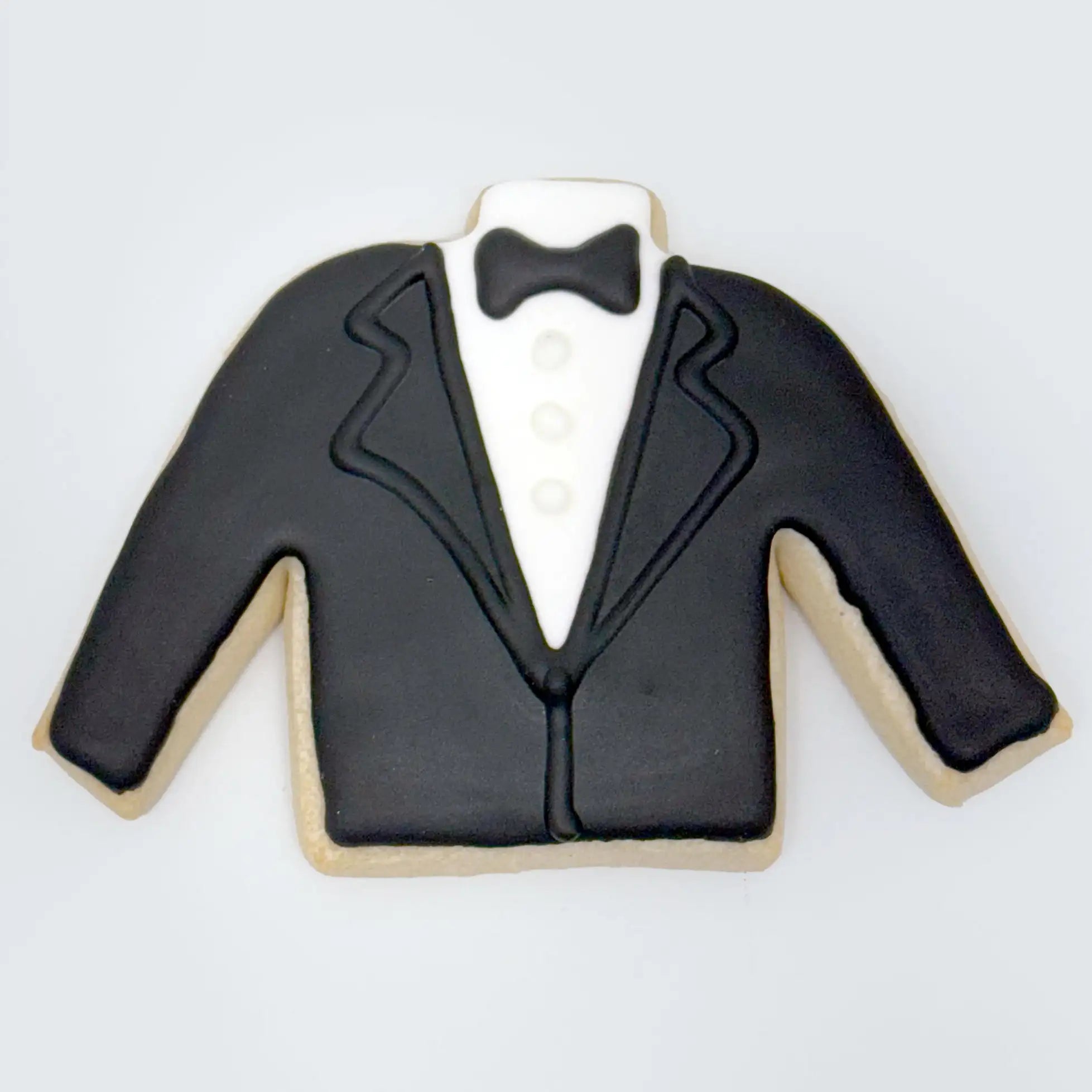 Tuxedo jacket-shaped cookie decorated with black icing for the suit, white icing for the shirt and buttons, and a black bow tie at the top