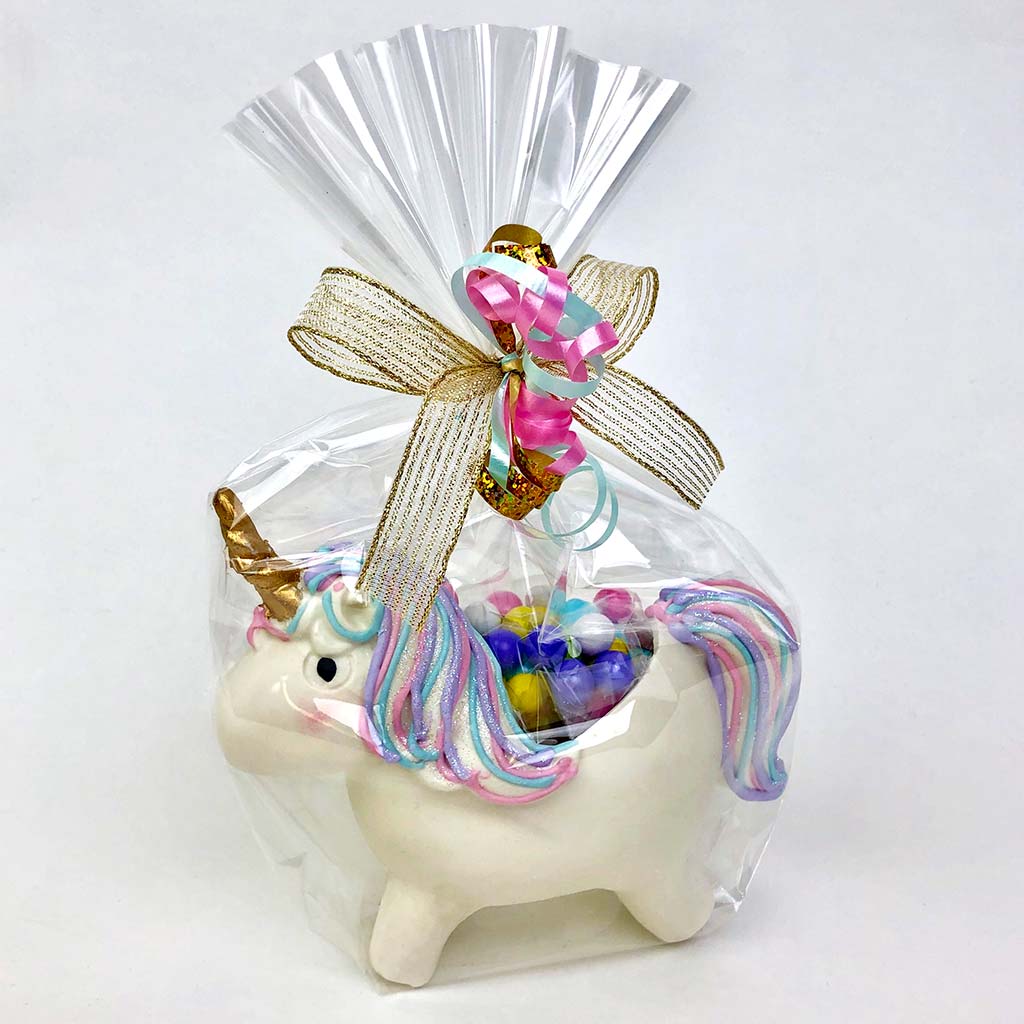 Chloe the Unicorn wrapped with cellophane, bow and ribbons and filled with candy
