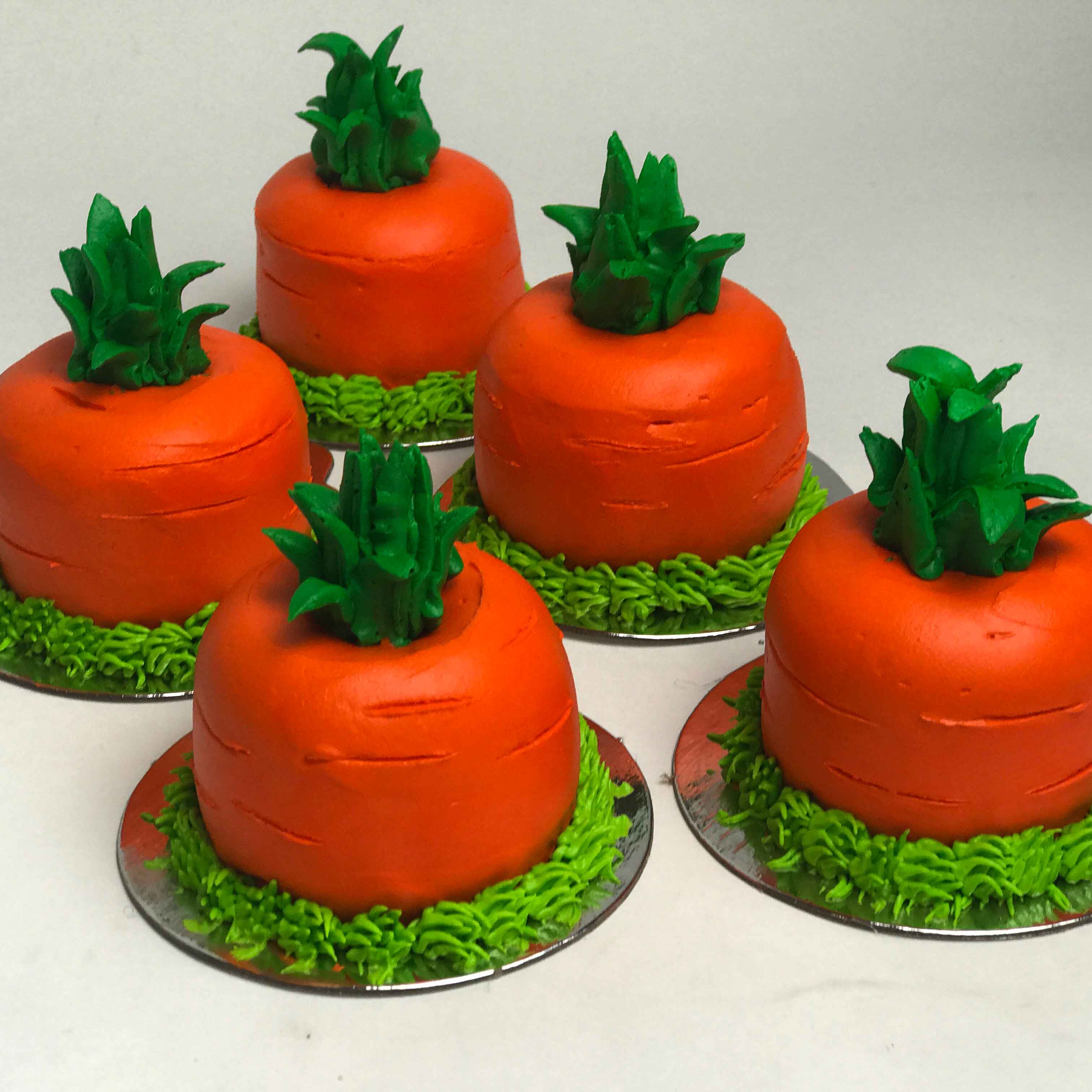 Five orange Easter Carrot 3D Cupcakes sitting individually on a silver base.