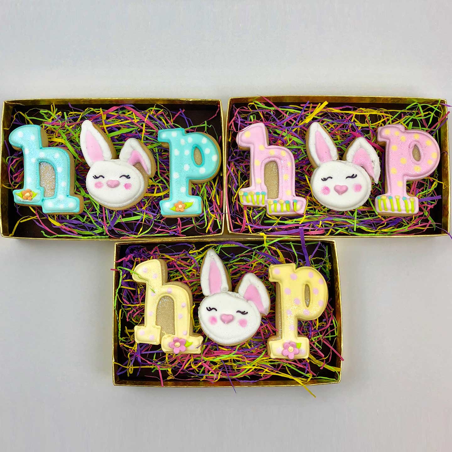 Blue, Pink, and yellow HOP Easter Cookies in boxes