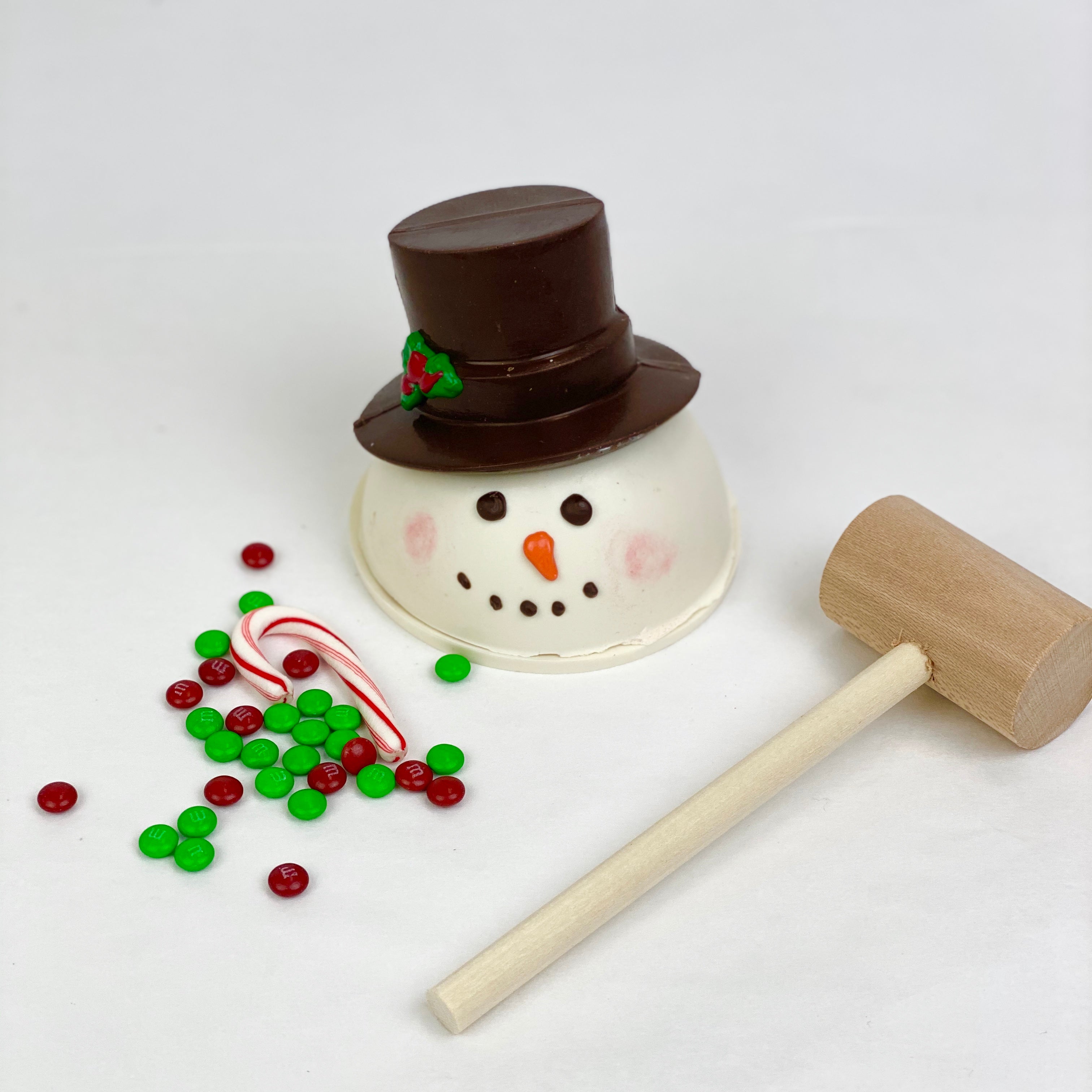 Snowman Chocolate Pinata, red and green M&Ms, candy cane and a mallet