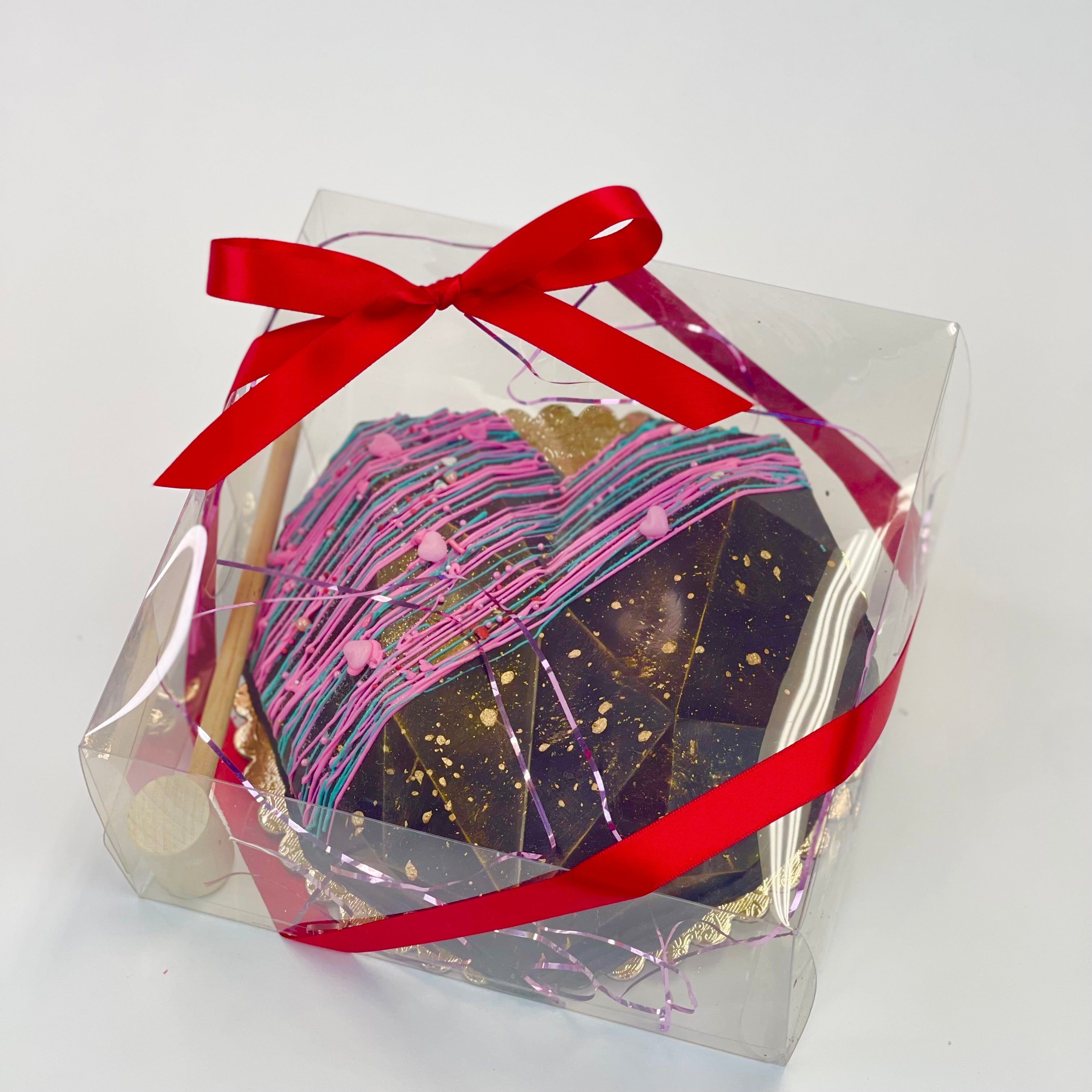 A Candy-filled Chocolate geode heart, a wooden mallet on a 9" board inside a clear box, wrapped with a red ribbon.